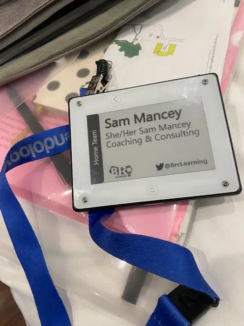 Sam Mancey’s name badge with pronouns she/her and “Coaching & Consulting,” displayed on website to highlight professional identity.